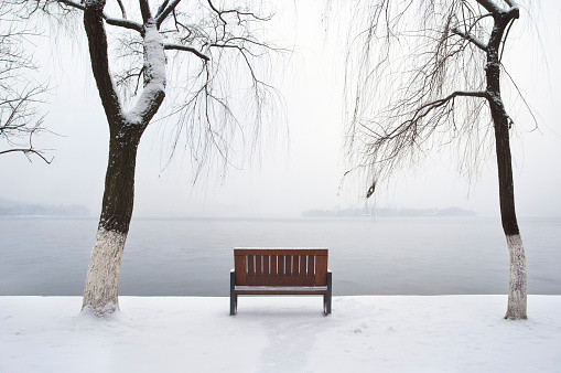 HANGZHOU, CHINA - JAN 4, 2013 - Lonely winter bench beside West Lake, Hangzhou