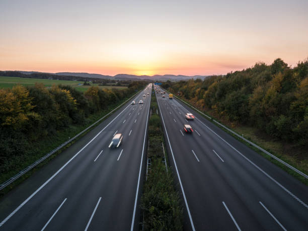 o tráfego rodoviário em uma estrada ao pôr do sol - autobahn - fotografias e filmes do acervo