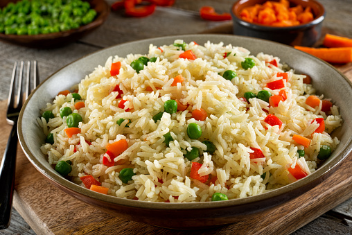 Delicious vegetable rice pilaf with green peas, carrots and red peppers.