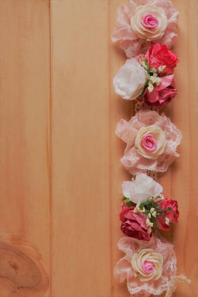 istock artificial flower on wooden background 953844312