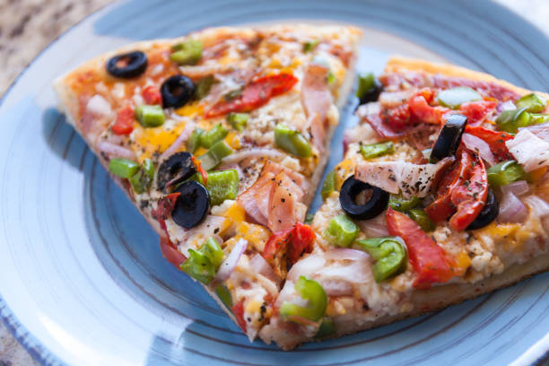 istock Making pizza. Cook's hand sprinkles olives. American style, cooking in a baking dish 953848434