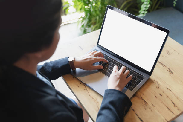 Business women using laptop with blank screen at table in the office.