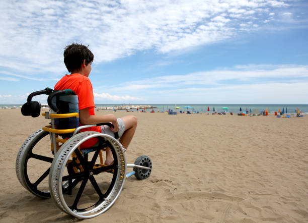 boy with orange t-shirt sitting on the wheelchair with aluminum - esclerose lateral amiotrófica imagens e fotografias de stock