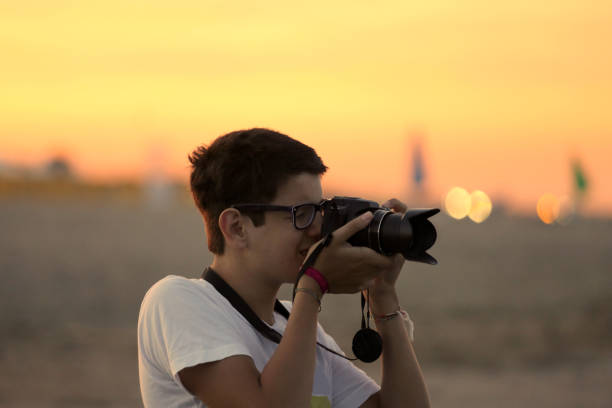 istock young boy takes a photograph with the camera 953853250