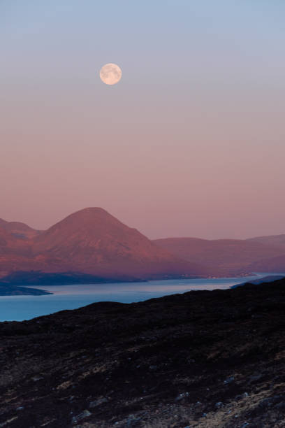 Cuillins of Skye, Scotland, pre dawn, with full moon above the snowy peaks.
