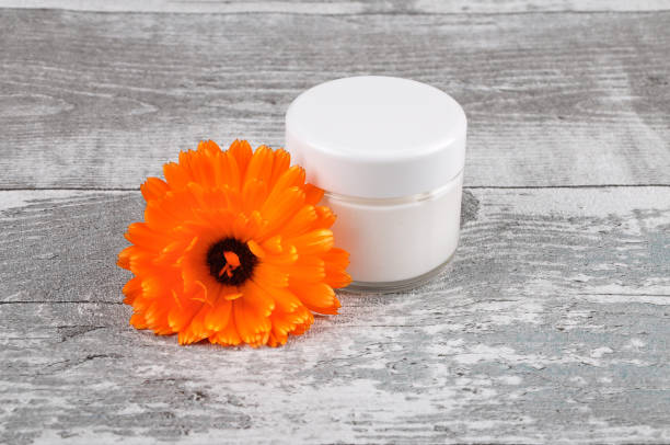 istock Natural cosmetics and common marigold on weathered wood 953854950