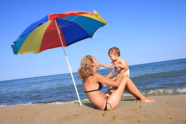 istock mother and baby on the beach 95385651