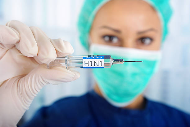 молодой врач держит вакцины-h1n1 - influenza a virus стоковые фото и изображения