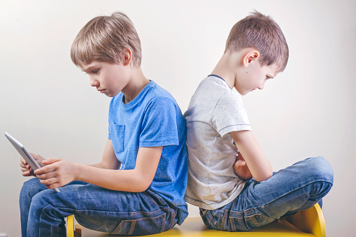 Children Computer Addiction Computer Addiction One Boy Using Tablet And Other Kid Sitting Angry ...