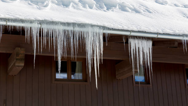 istock snow covered roof with icicles 953865544