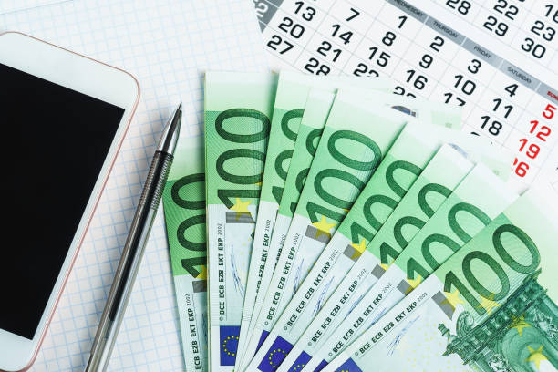 istock Several hundred-dollar bills, a calendar, a notebook, a pen and a smartphone 953870880