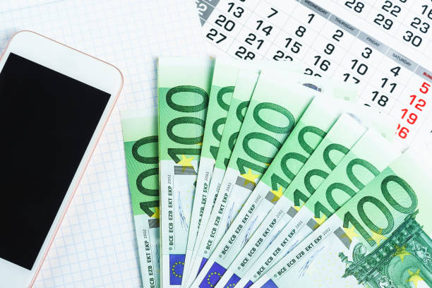 istock Several hundred-dollar bills, a calendar, a notebook, and a smartphone 953870884