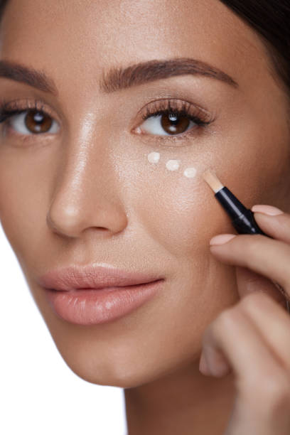 istock Cosmetics. Beautiful Woman Applying Concealer, Doing Makeup 953873374