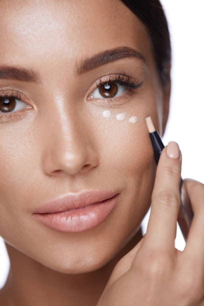 istock Cosmetics. Beautiful Woman Applying Concealer, Doing Makeup 953873472
