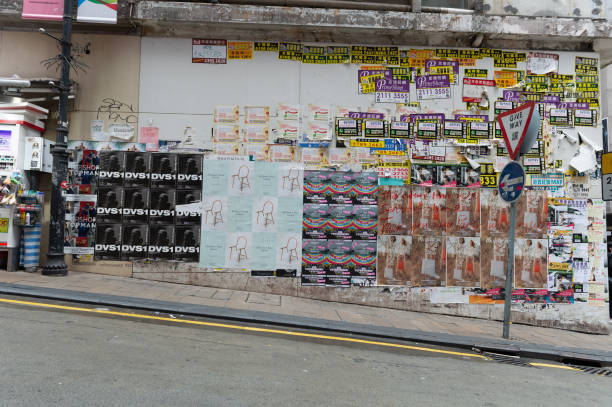 central, hong kong - por volta de abril de 2018: anúncio os cartazes na parede. - textured urban scene outdoors hong kong - fotografias e filmes do acervo