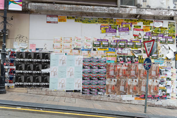 central, hong kong - por volta de abril de 2018: anúncio os cartazes na parede. - textured urban scene outdoors hong kong - fotografias e filmes do acervo