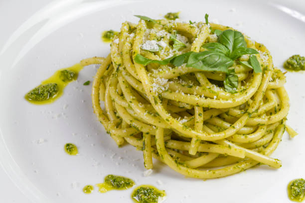 Spaghetti pasta Bucatini with pesto sauce and parmesan from wild garlic in white dish. Spaghetti pasta Bucatini with pesto sauce and parmesan from wild garlic in white dish pesto sauce stock pictures, royalty-free photos & images