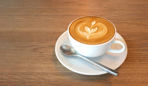 istock Hot coffee cappuccino latte art top view on wooden table background 953879262