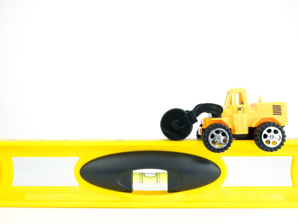 Toy Pressure road car with building level on white background, Engineering construction concept.