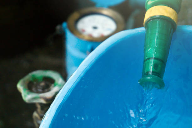 istock Bucket with water overflowing. And water meter behind scene. 953884224