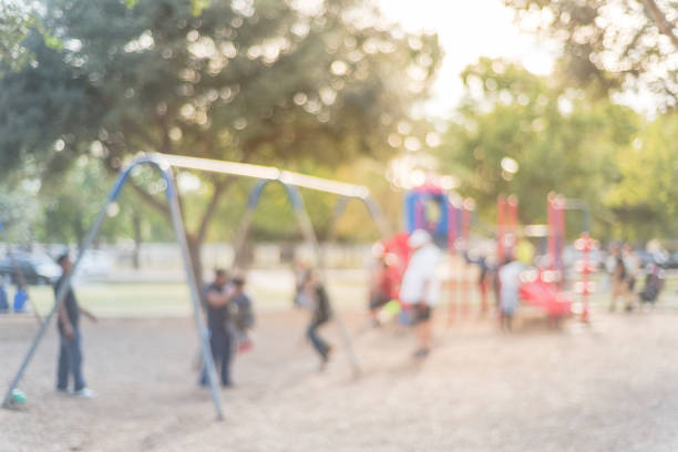 istock Blurred motion kids swing back and forth at public playground in USA 953887250