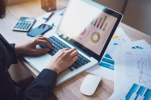 istock Close up of business women sitting be using laptop for analyst statistics document her workplace in office. Workplace strategy Concept. 953887278
