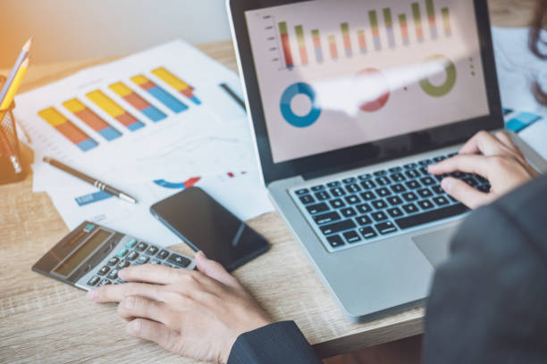 istock Close up of business women sitting be using laptop for analyst statistics document her workplace in office. Workplace strategy Concept. 953887340