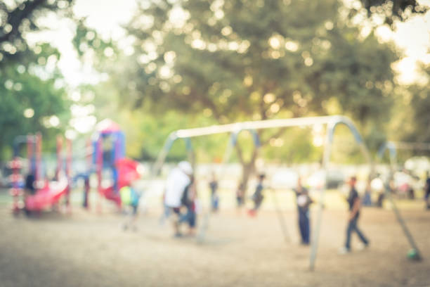 istock Blurred motion kids swing back and forth at public playground in USA 953887616