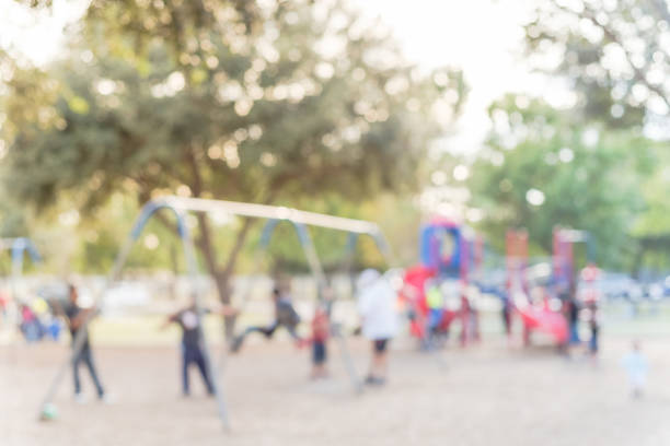 istock Blurred motion kids swing back and forth at public playground in USA 953888344