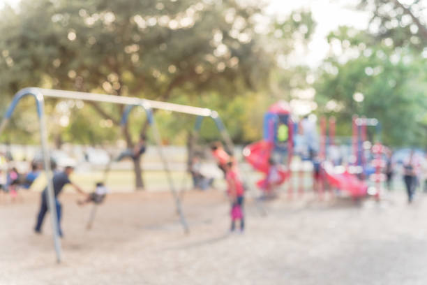 istock Blurred motion kids swing back and forth at public playground in USA 953891722