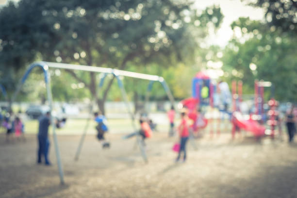 istock Blurred motion kids swing back and forth at public playground in USA 953892072