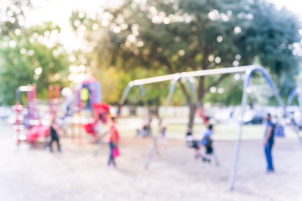 istock Blurred motion kids swing back and forth at public playground in USA 953892132