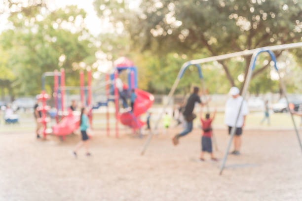istock Blurred motion kids swing back and forth at public playground in USA 953892332