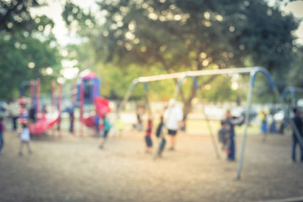 istock Blurred motion kids swing back and forth at public playground in USA 953892408