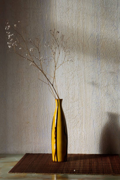 istock vase with a dry branch on the wall 953901570