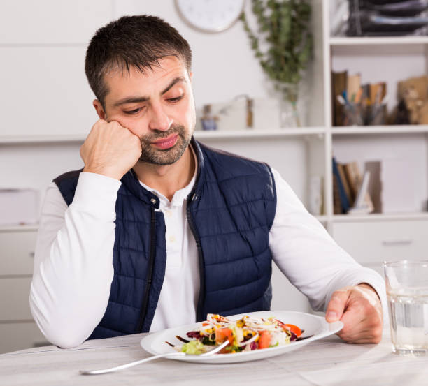 istock Young male looking at vegetable salad before eating 953905418