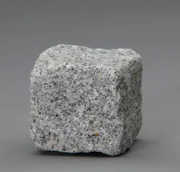 Photo of Granite cube on gray background