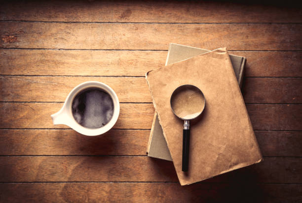 istock White cup with coffee and books with magnifier 953910360