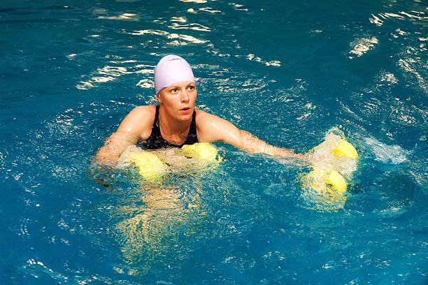 Girl in water with dumbbels stock photo