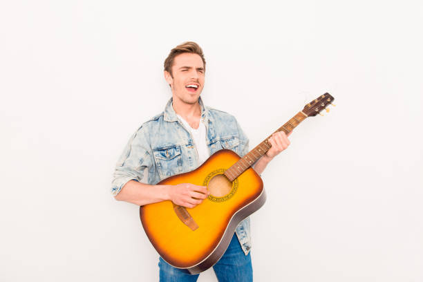 istock Young musician playing on the guitar and singing on white background 953912494
