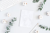 Paper blank, cotton flowers, eucalyptus branches. Flat lay, top view