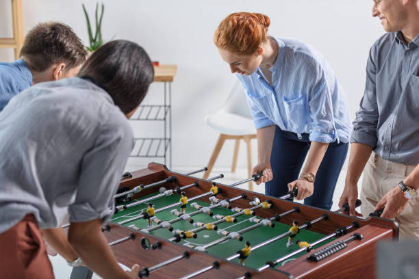 istock Young team playing table football in modern office 953920750