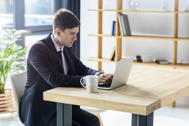 istock Young businessman working on laptop in modern office 953924208
