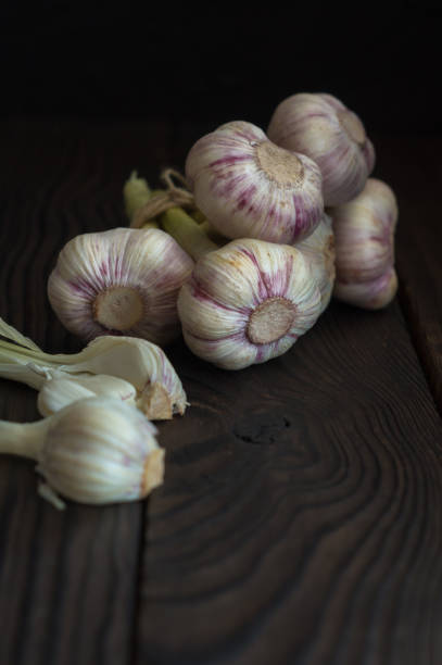 istock Garlic heads on dark wooden table 953925134