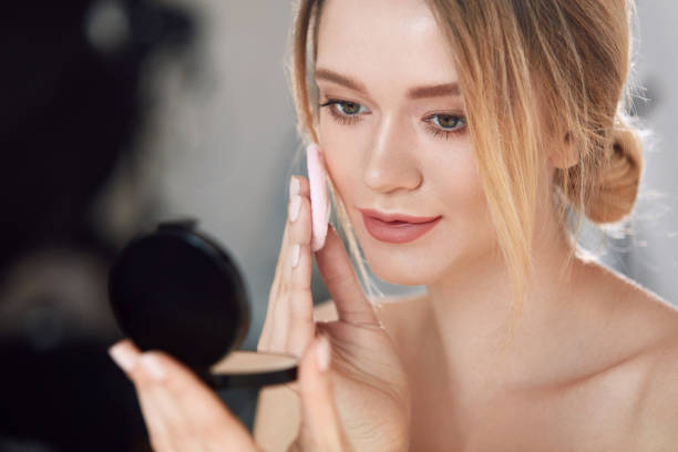 istock Face Make-Up. Female With Mirror Putting Cosmetic Powder 953928792