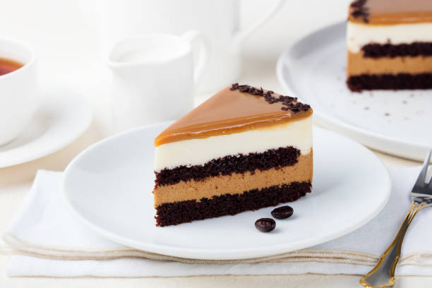 карамельный торт, муссовый десерт на тарелке. белый фон. - кусок торта фотографии стоковые фото и изображения
