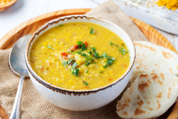 Lentil soup with pita bread in a ceramic white bowl on a wooden background. Close up. Lentil soup with pita bread in a ceramic white bowl on a wooden background. Close up soup lentil healthy eating dishware stock pictures, royalty-free photos & images