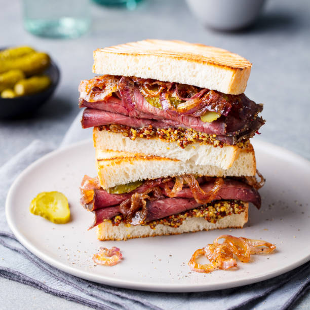 istock Roast beef sandwich on a plate with pickles. 953937504