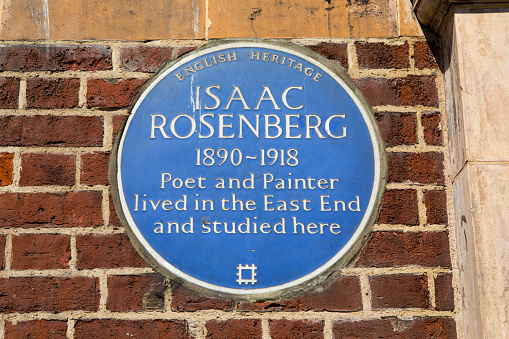 London, UK  - April 19TH 2018: A blue plaque marking the location where Poet and Painter Isaac Rosenberg once lived and studied on Whitechapel Road in London, UK - image taken on 19th April 2018.