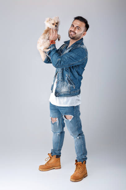 istock man in denim jacket holds pomeranian dog. 953946352